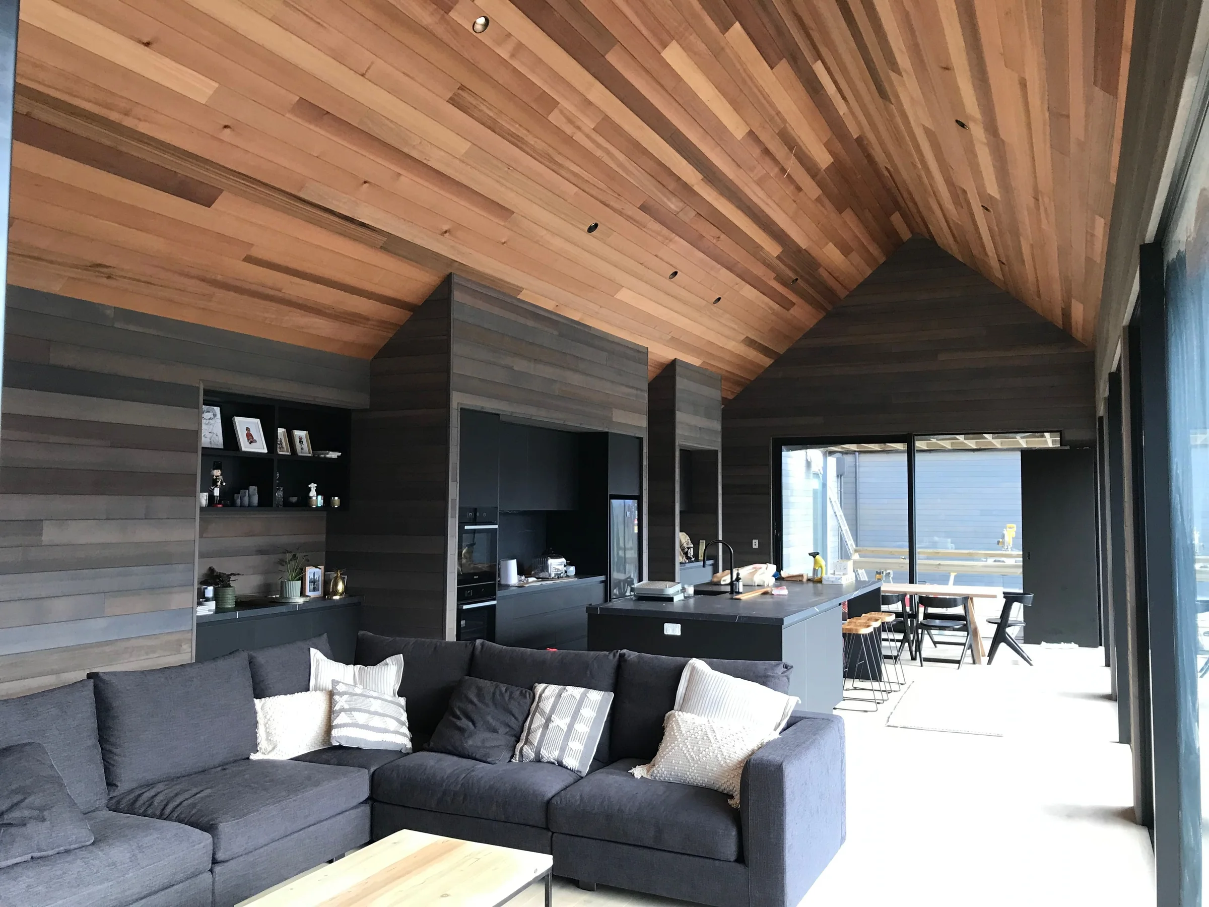 Expansive timber-lined Queenstown living space with stone and full-height glazing